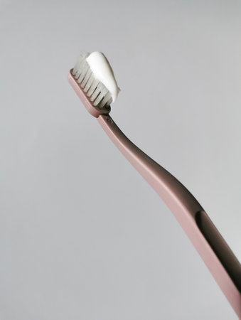 Plastic pink toothbrush with paste for daily morning oral care.の写真素材