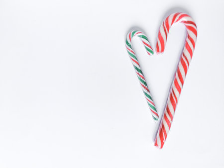 Winter romantic with Christmas lollipops in heart form. Red, green and white spiral stripes.