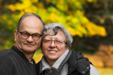 Happy senior couple tourists walking in Warsaw autumn city park. nature background. Smiling elderly...