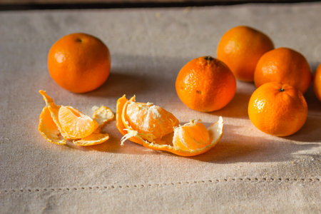 Pile of ripe orange tangerine fruits isolated on a linen tablecloth. Healthy eating and diet with fruits concept. Traditional sweet food for winter holidays. Preparation for New Year or Christmas eve.の写真素材