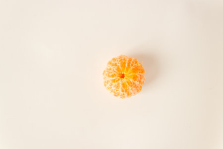 Top view of whole pelleted tangerine citrus orange fruit on a white background. Fasting day with healthy fruitarian snack. Space for text.の写真素材