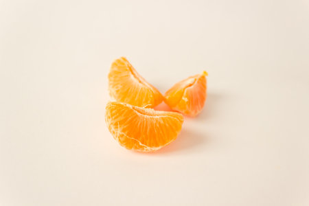 Three ripe peeled tangerine slices isolated on white background. Fruitarian and raw food diet concept. Space for text. horizontal photo.の写真素材