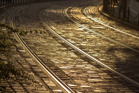 Tram tracks on stone-paved road at sunset. Old european street of Poznan, Poland in summer time. Tram rails at sunshine.の写真素材