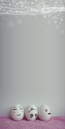 Three eggs with cheerful faces upside down vertical. A photo with a place under the text for your designの写真素材