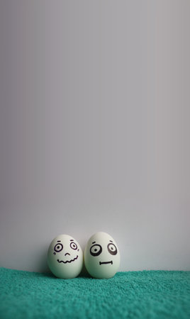Eggs with faces photo for your design. With a place under the text. Funny and cute. Two eggs on green grass clothの写真素材