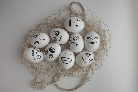 Eggs in a grid photo for your design. Funny and cute lie on a gray table entangled in a grid