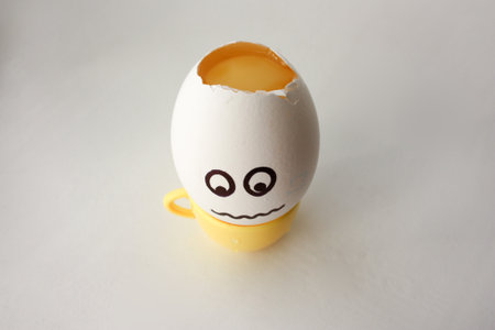 An egg with a face. Funny and sweet. HEADACHE. HEAD IS SHOCKED. TREAT CUP COFFEE. FILLING IN THE CUP. Photo for your design.の写真素材