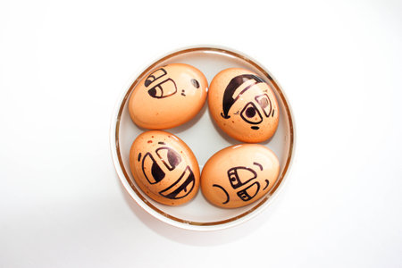 Eggs with painted face. Photo for your design. Eggs float in a plate. Four eggs.の写真素材