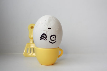 cook. head spin. The concept of steaming at work. An egg in a mug upside down. Photo for your design.の写真素材