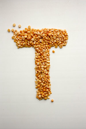 The letter T. English alphabet from cereals. Vertical orientation of the sheet. Photo for your designの写真素材