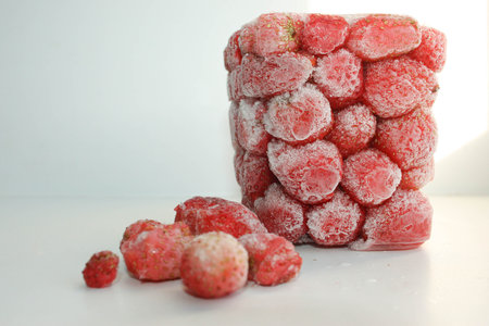 Strawberry frozen with ice with separately lying berries. Photo for your design