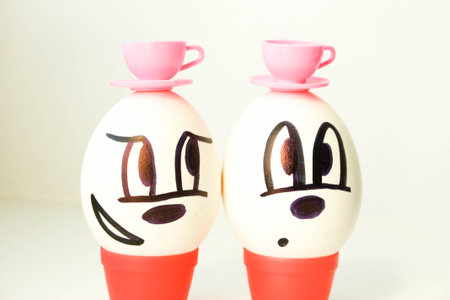 Tea drinking concept. two friends. The egg is pleased with the painted face. on a white background....