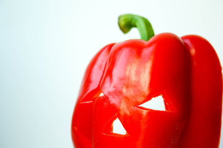 Halloween. Pepper red with an eerie face and slits between the eyes. on a white background. Photo for your designの写真素材