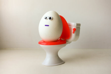 hemorrhoids. Eggs with a funny painted face on the toilet. Photo for your design.