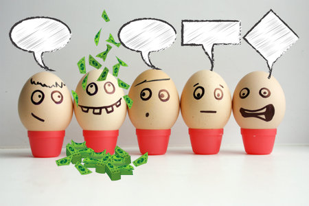 Business concept. Profitable business. Eggs with painted face. Concept of the first September lineup. Meeting calls roll call. Funny face photo for your design. With a lot of money, dollars pouring down on his head.の写真素材