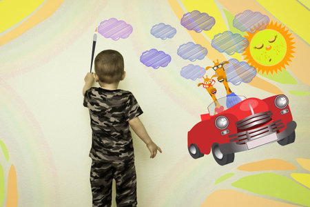 Concept of traveling with a child. The little boy draws on the wall. Machine with a pair of giraffes. Photo illustration for your design.の写真素材
