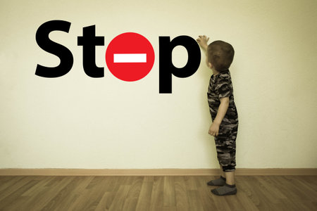 Concept of cautiously children on the road. Stop. The little boy draws a stop sign on the wall. Fantasy for children. Photo illustration for your design.の写真素材
