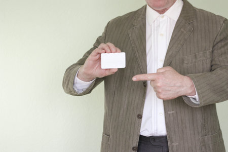 Business concept businessman. Business card in the businessman's hand. Points to the business card. Photo for your designの写真素材