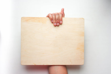 Advertising concept. A female hand holds an empty sign. Horizontal orientation. Photo for your designの写真素材