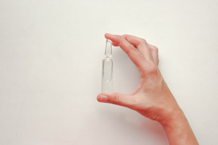 Medicine and vaccine concept. A female hand holds an ampoule. Photo for your designの写真素材
