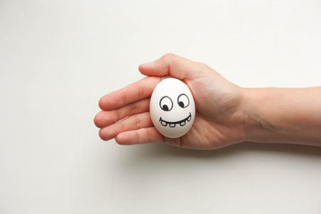 Diet and nutrition concept. The egg is fresh with a funny face with teeth. hunger. Photo for your designの写真素材