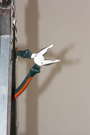 Construction concept. Pliers and stepladder. Vertical sheet orientationの写真素材