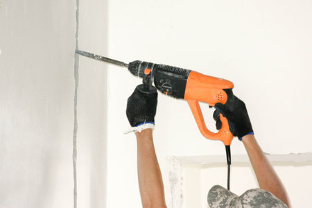 Construction concept. Puncher and wall in work. Horizontal sheet orientationの写真素材