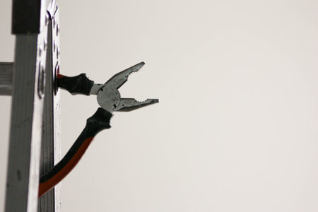 A construction concept. A pliers on a white background and a stepladder. Photo for your design. Horizontal sheet orientationの写真素材
