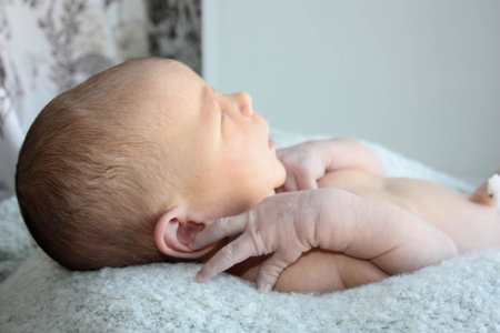 the newborn baby is sleeping. on pastel woolen fabric in profile.の写真素材