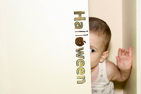 Halloween. the boy is hiding in the closet. fear of children. inscription halloween and pumpkinの写真素材