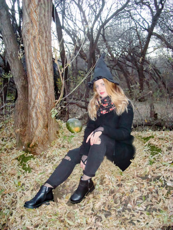 Halloween witch iles. beautiful girl sitting on the ground
