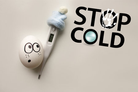 cold stop concept. photo with text for your design. an egg with a funny sad face in a blue cap with...