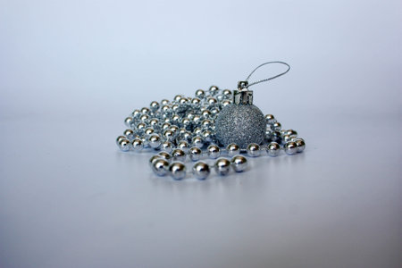 Christmas tree. decoration for spruce. silver beads. photo for your design. pile of round beads with a Christmas tree in sequinsの写真素材