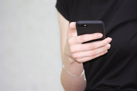 smart phone and girl. girl in black on a white background. horizontal orientation of the sheet.の写真素材