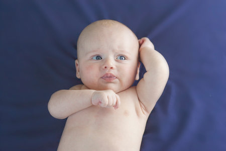 crying baby. little child on a blue sheet