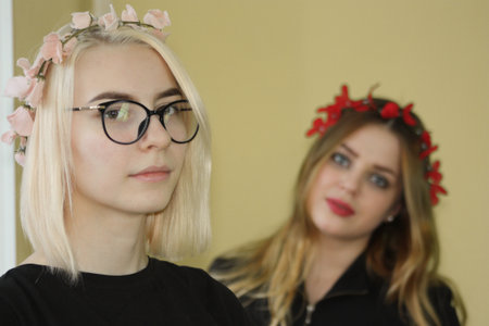 Hi spring. two friends. wreaths of flowers. youth and beautyの写真素材