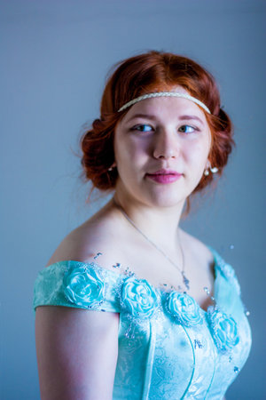 smiling tender girl. Portrait of a beautiful red-haired girl. baroque. in a blue ball gown. vertical...