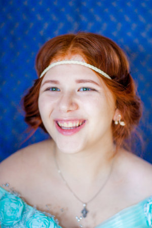 Hello summer. portrait of a red-haired girl wearing an outfit blue dress. naughty laughterの写真素材