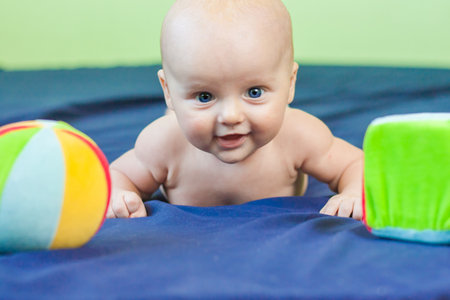 happiness is childish. the baby is attractive and cute with great inviting blue eyes. among toys. children's roomの写真素材
