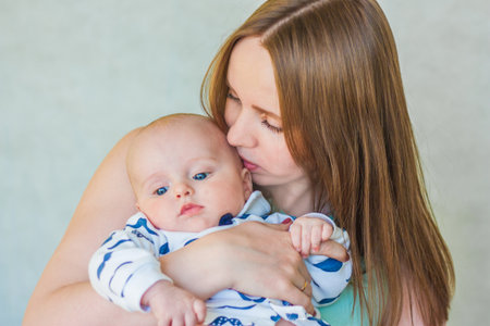 mother's kiss. the baby is cute and sympathetic. Mother and son. portrait on white background