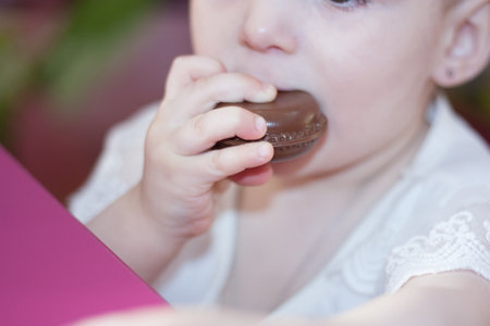 sweet chocolate cake and a little girl is eating chocolate cake. harmful food. absence of dietの写真素材
