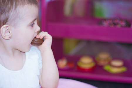 choice in the storefront. sweet chocolate cake and little girl eating a cupcakeの写真素材
