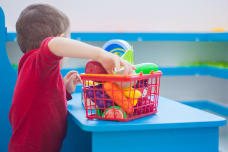 shopping cart. cost of living for a basket of products in the store. fruits and vegetables. living wage. child in red jumperの写真素材