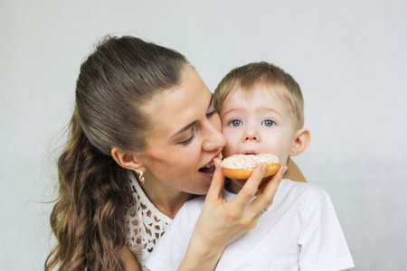 proper nutrition for the child. mom and baby eat donut sweetの写真素材