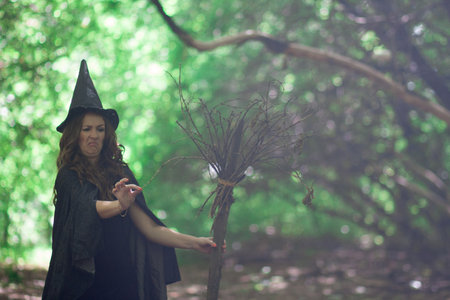 Halloween. The witch is funny. The old broom. The broom broke. The squeamish witch in the hood of the witchの写真素材