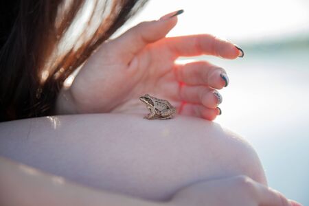 Queen in a green dress with a train and emerald eorone. Sexy brunette on the lake. Girl on the...