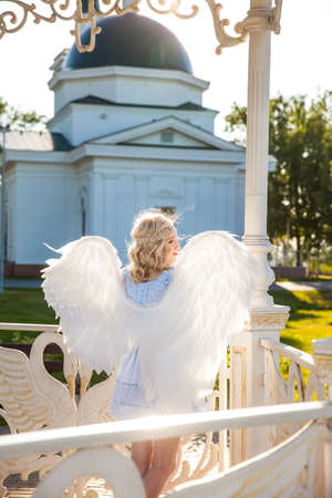 Angel girl with large white feather wingsの写真素材