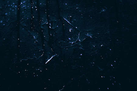 Rock texture. Dark stone wall. Stone background. Rock surface with holography, nacre. Wall abstraction. Paint spots. Rock surface with cracks. Abstract texture.の写真素材