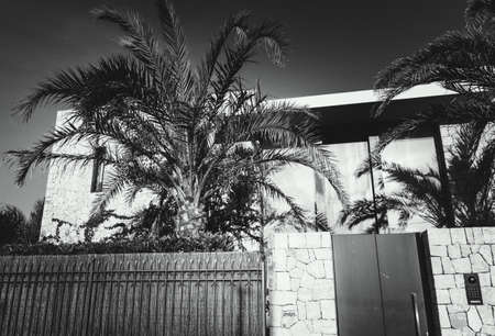 A cozy street overlooking of the facade of the building and of a stone fence, Mallorca, Spain. Black...