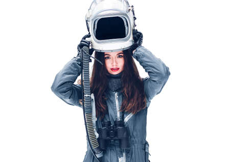 Astronaut girl in space helmet. Isolated on white background. Young girl in an astronaut suit. Space helmet. Background wallpaper. Another world. Space people. Cosmic atmosphere. Free space for text.の写真素材